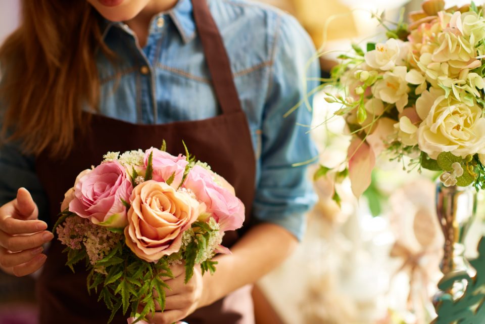 Florist preparing bouquet of flowers for client